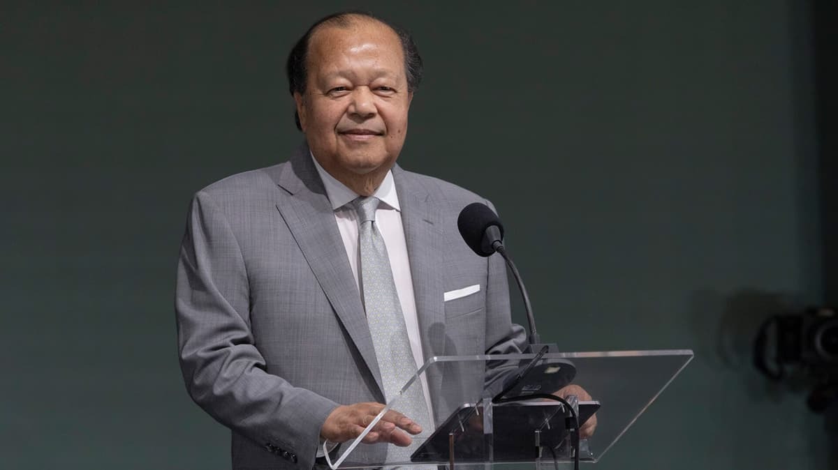 Prem Rawat speaks at a podium during his event in Bologna, Italy